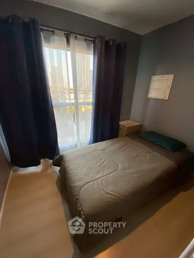 Cozy bedroom with modern decor and large window offering city views.