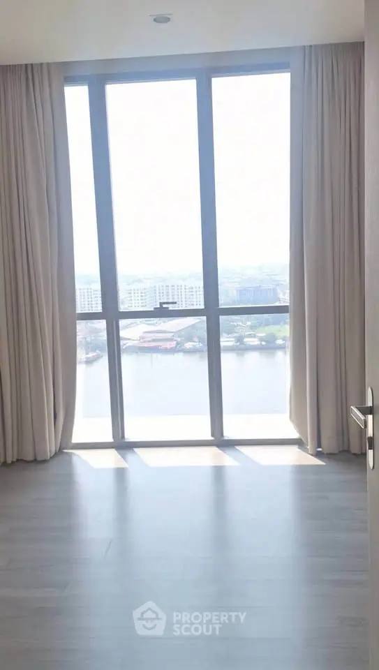 Bright room with large window offering stunning river view, perfect for a serene living experience.