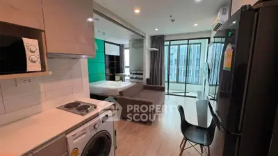 Modern studio apartment with open layout, featuring kitchen, living area, and balcony access.