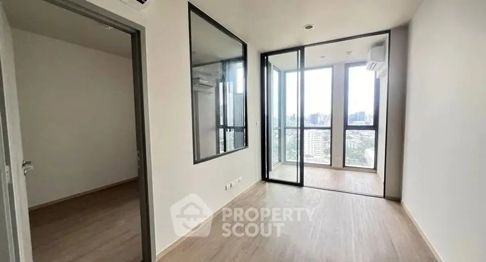 Modern apartment with floor-to-ceiling windows and city view, featuring a spacious balcony.