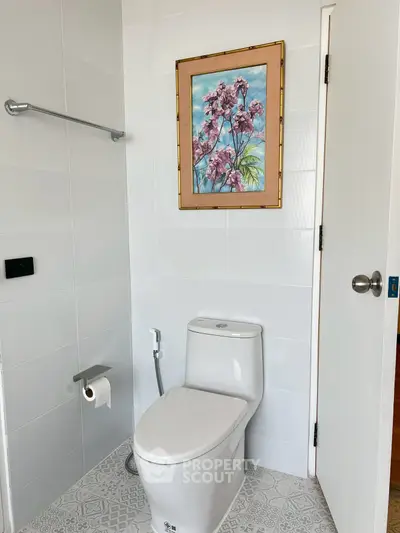 Modern bathroom with elegant painting and sleek white fixtures