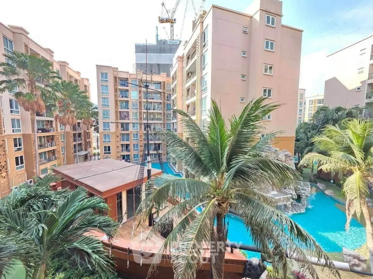 Luxurious apartment complex with pool and palm trees, perfect for resort-style living.
