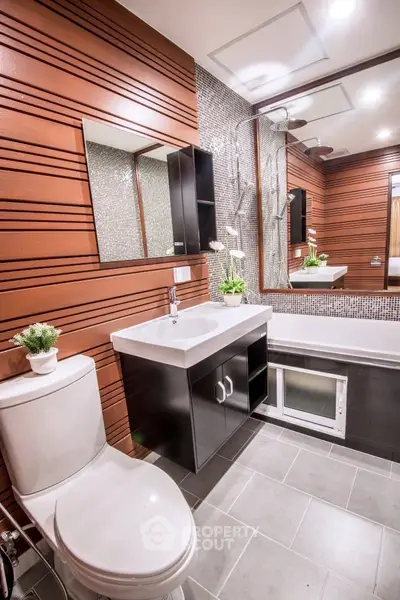 Modern bathroom with sleek design, featuring a bathtub and stylish fixtures.