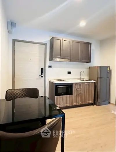 Modern kitchen with sleek cabinets and stainless steel appliances in a cozy apartment.