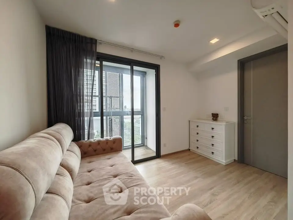 Modern living room with plush sofa and city view balcony
