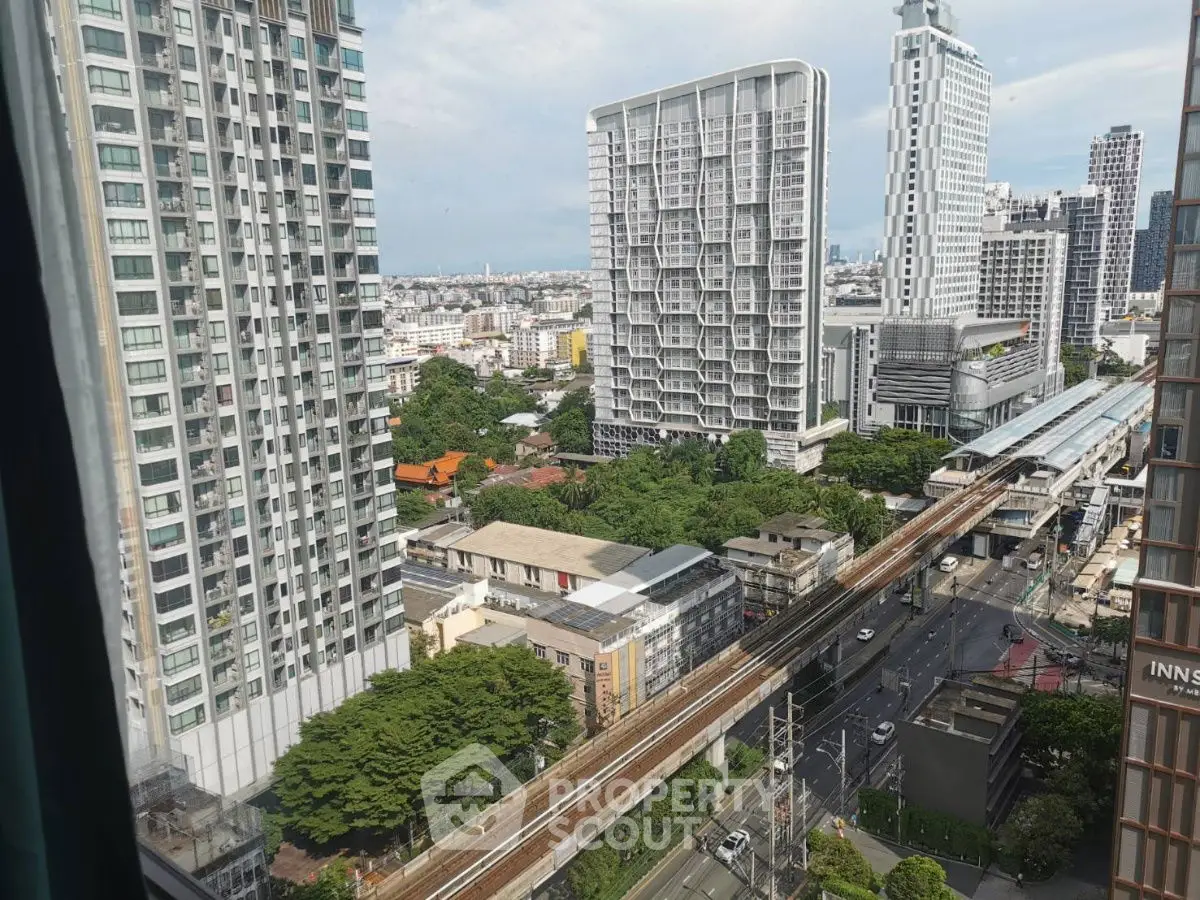Stunning urban view from high-rise apartment overlooking city skyline and transit line.