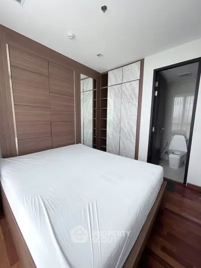 Modern bedroom with ensuite bathroom and stylish wooden wardrobe
