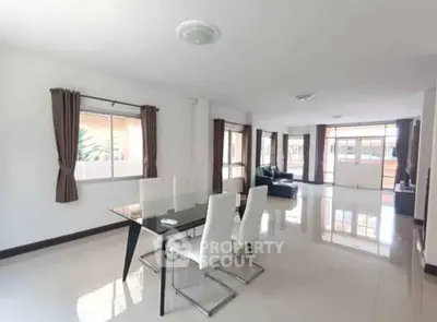 Spacious modern living room with elegant dining area and large windows for natural light.