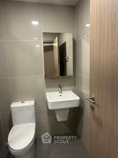 Modern minimalist bathroom with sleek fixtures and neutral tones.