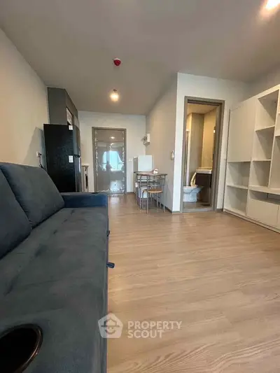 Modern living room with sleek furniture and open layout, featuring a cozy sofa and stylish flooring.