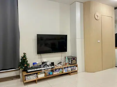 Modern living room with wall-mounted TV and stylish storage solutions.