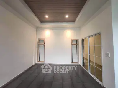Spacious modern room with sleek tiled flooring and recessed lighting, perfect for versatile living space.