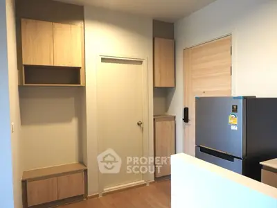 Modern kitchen with sleek cabinets and stainless steel fridge in a compact layout.