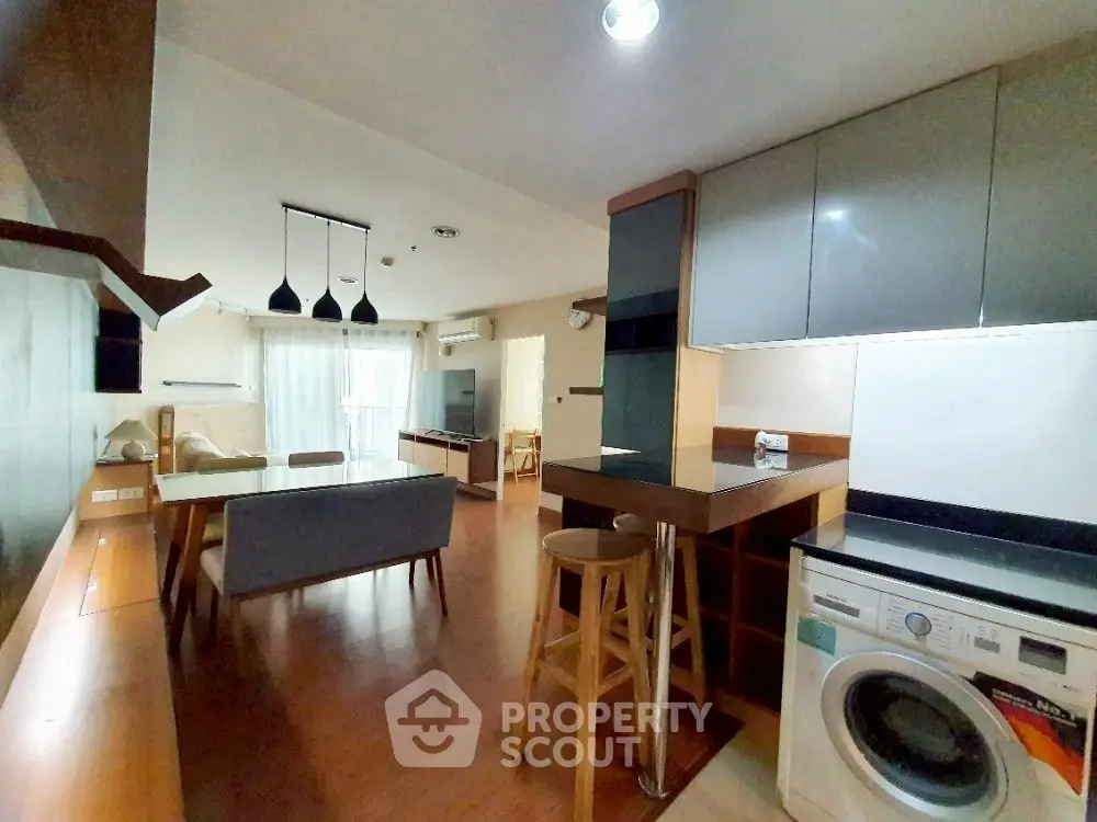 Modern open-plan living area with stylish kitchen and washing machine