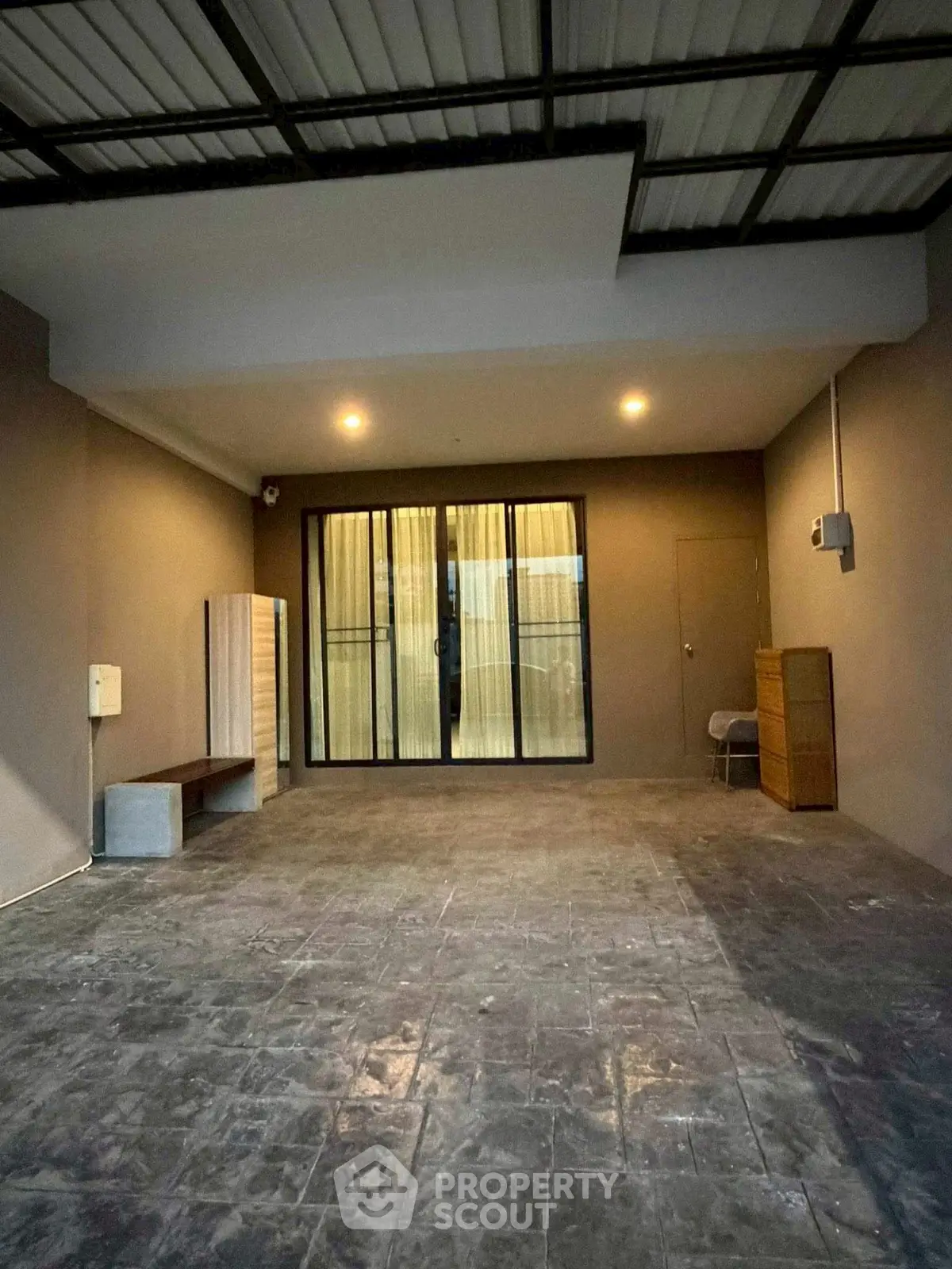 Spacious covered parking area with modern lighting and sliding glass doors.