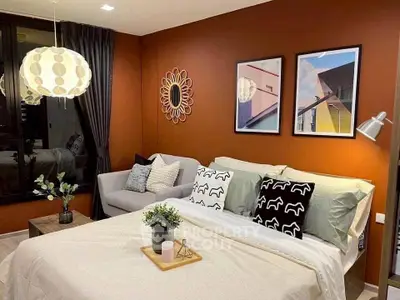 Stylish bedroom with modern decor and cozy seating area, perfect for relaxation.