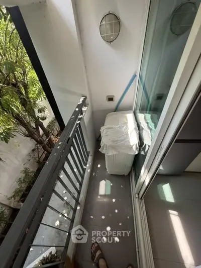 Charming small balcony with natural light and garden view, perfect for relaxation.