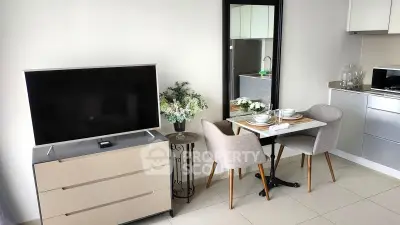 Modern living room with sleek TV, dining set, and stylish decor in a contemporary apartment.
