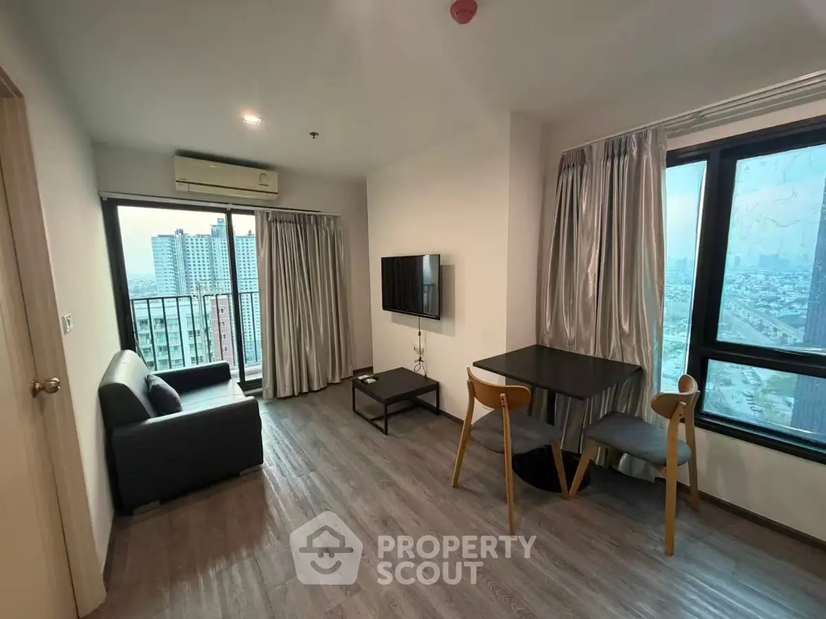 Modern living room with city view, sleek furniture, and natural light.