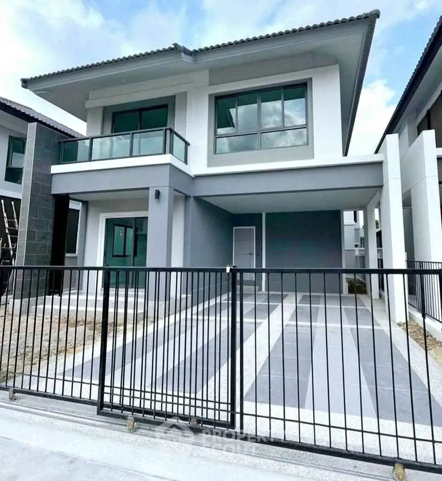 Modern two-story house with sleek design and spacious driveway in a suburban neighborhood.