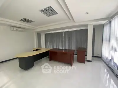 Spacious office space with modern desks and large windows for natural light.