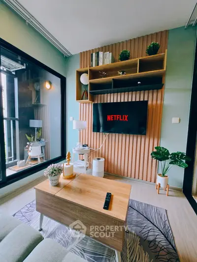 Modern living room with stylish decor and large TV, perfect for entertainment and relaxation.