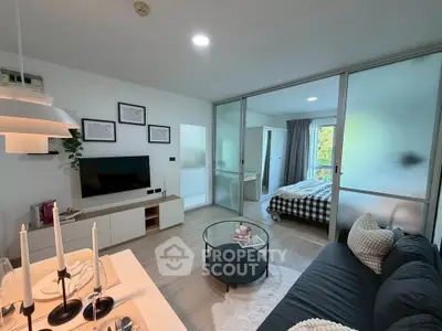Modern open-plan living room with stylish decor and sliding glass doors to bedroom.