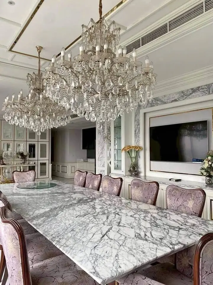 Luxurious dining room with elegant chandeliers and marble table, perfect for upscale gatherings.