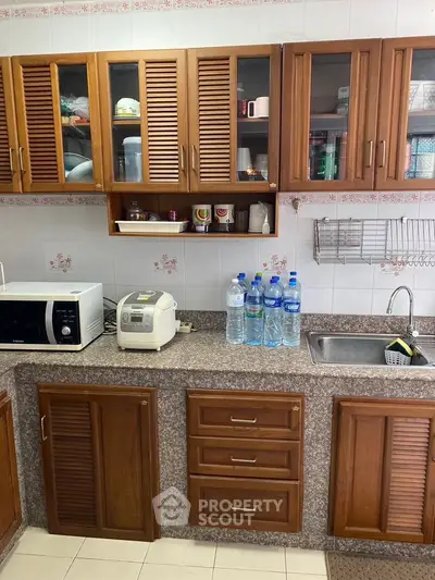 Charming kitchen with wooden cabinets and modern appliances, perfect for culinary enthusiasts.