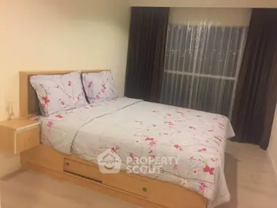 Cozy bedroom with floral bedding and modern wooden furniture, perfect for relaxation.