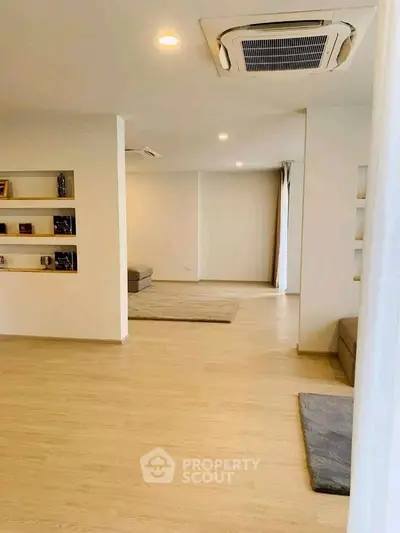 Spacious modern living room with built-in shelves and cozy seating area.