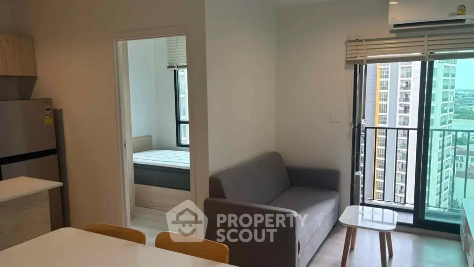 Modern apartment interior with cozy living room and bedroom view, featuring a balcony with cityscape.