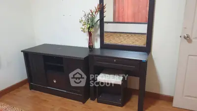Elegant bedroom setup with dark wood furniture and decorative mirror