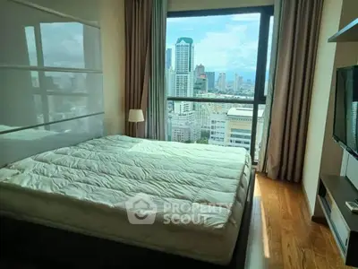 Modern bedroom with city view and large window in high-rise apartment