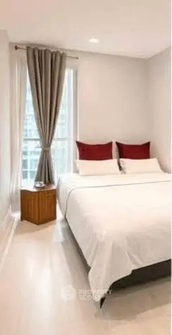 Cozy bedroom with modern decor and large window offering natural light