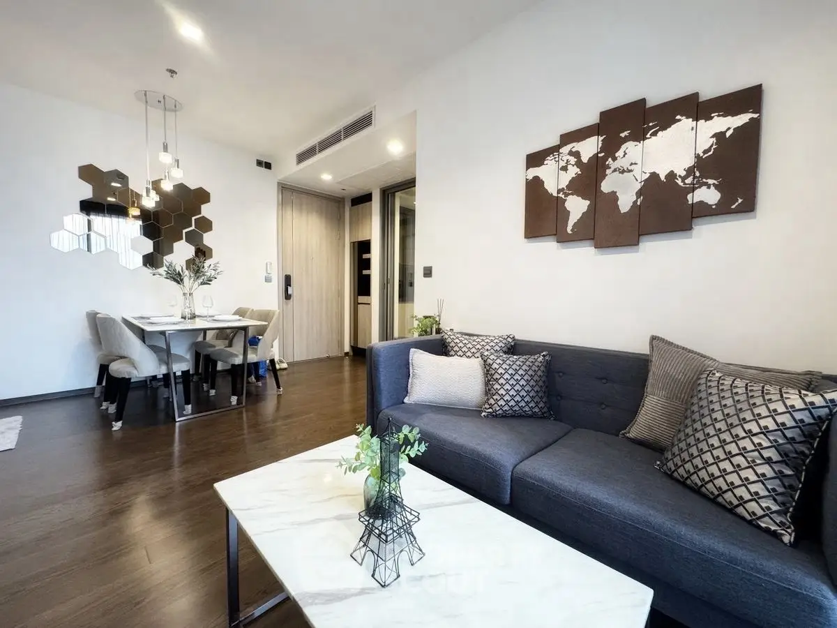 Modern living room with stylish decor and dining area, featuring a world map wall art.