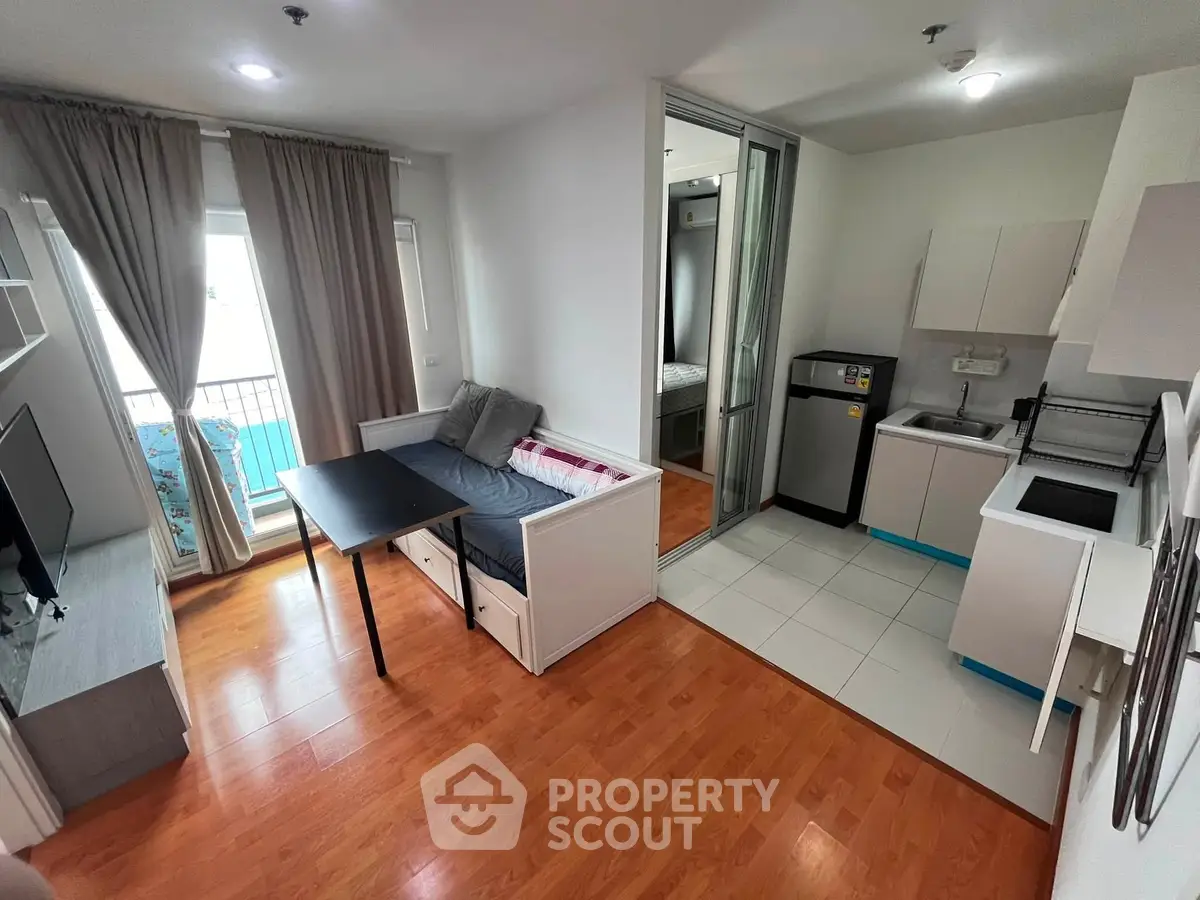 Modern open-plan living room with kitchen and balcony access in a stylish apartment.