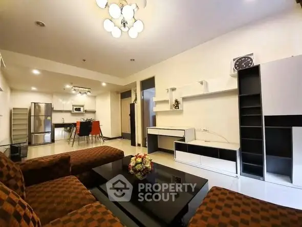 Spacious modern living room with open kitchen, stylish furniture, and elegant lighting in a contemporary apartment.