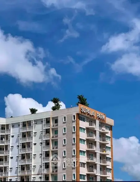 Modern high-rise building against a clear blue sky, showcasing urban living at Supalai Park.
