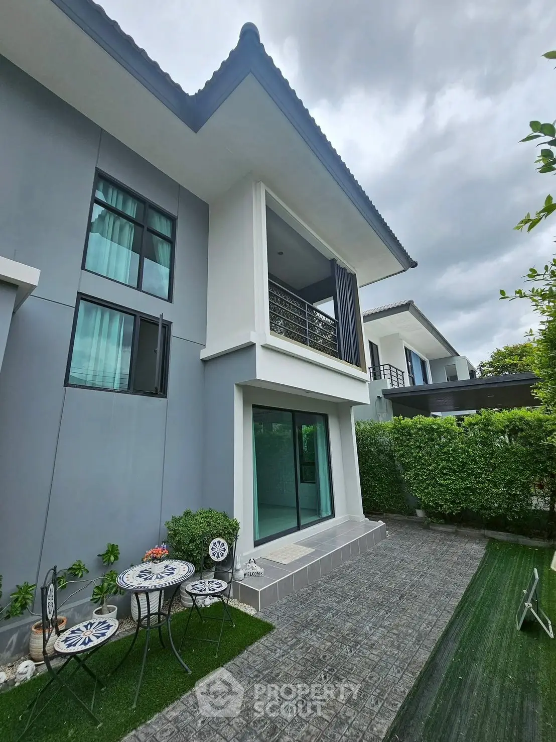 Modern two-story house with balcony and garden patio