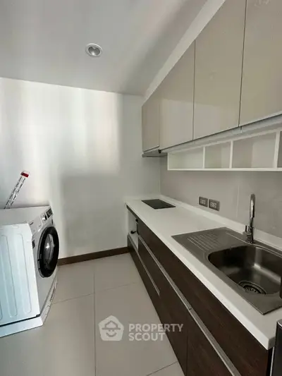 Modern kitchen with sleek cabinetry and built-in appliances in a compact layout.