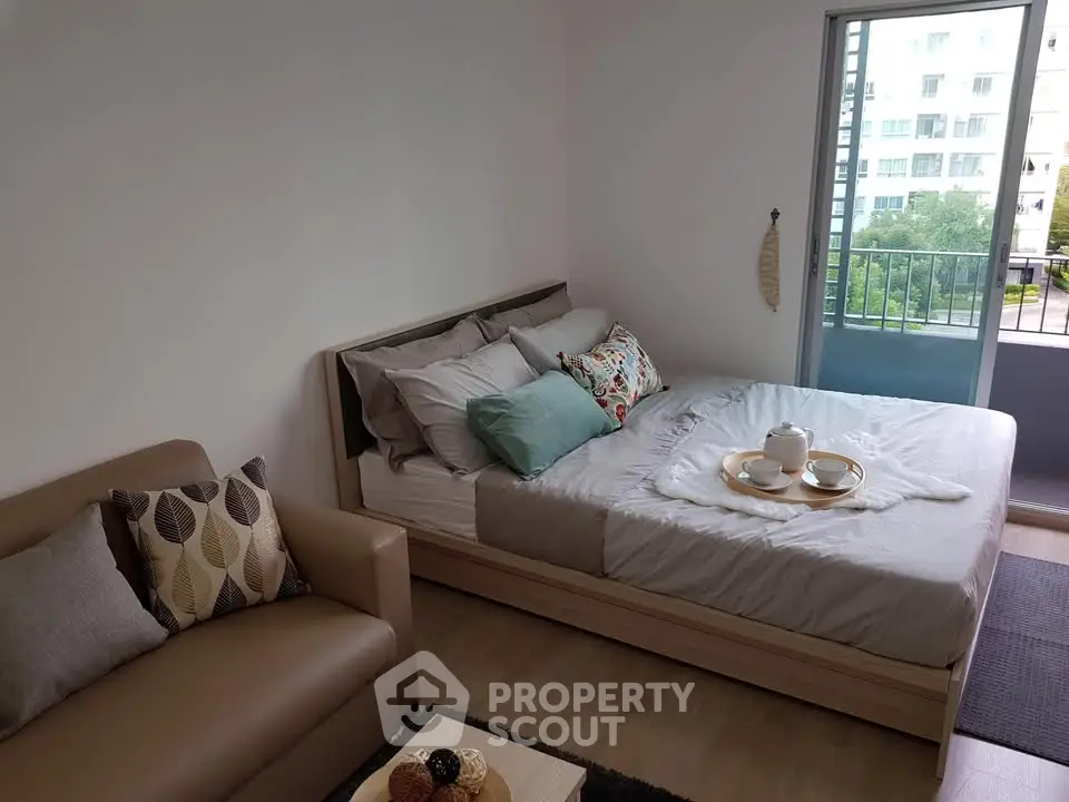 Cozy bedroom with modern decor and balcony view in a stylish apartment.