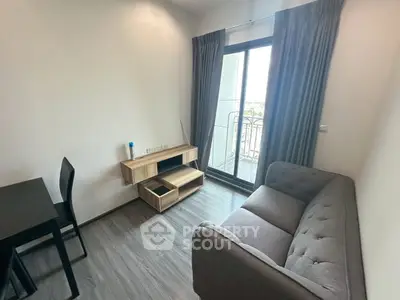 Modern living room with sleek furniture and balcony access in a stylish apartment.
