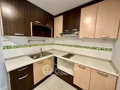 Modern kitchen with sleek cabinetry and electric stove in corner layout