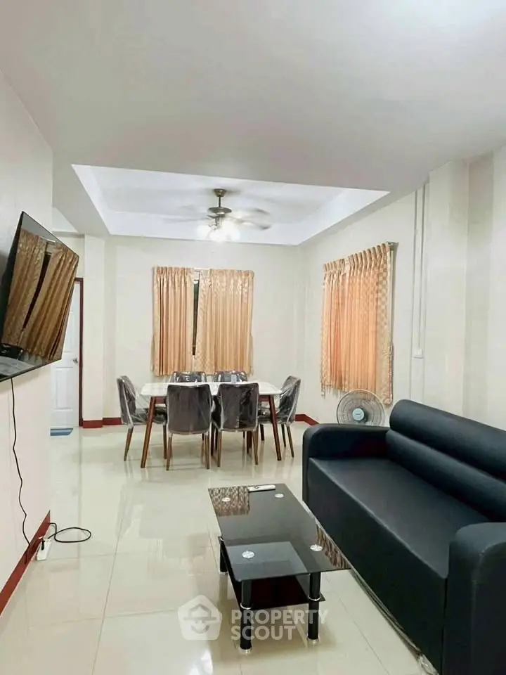 Spacious living room with modern furniture and dining area, perfect for family gatherings.