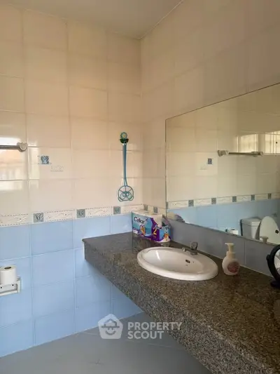 Spacious bathroom with elegant granite countertop and large mirror