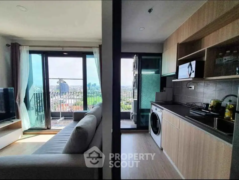 Modern apartment with open kitchen and living room, featuring a balcony with stunning city views.