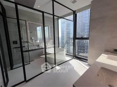 Luxurious modern bathroom with glass walls and city view, featuring a sleek bathtub and elegant fixtures.