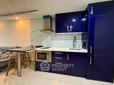 Modern kitchen with sleek blue cabinets and built-in appliances