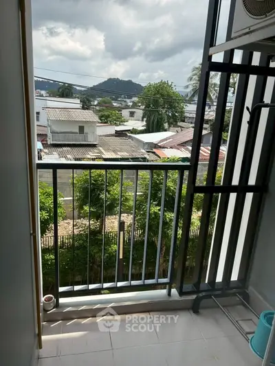 Charming balcony with scenic view of lush greenery and distant hills, perfect for relaxation.